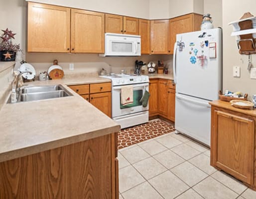 Brightly lit kitchen area with wooden cabinetry