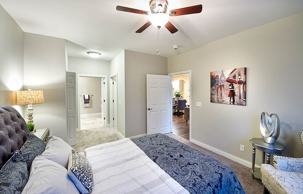 Inviting bedroom with a ceiling fan and an adjoining bathroom