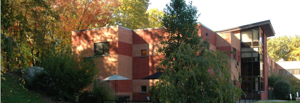 Hancock Hall building surrounded by trees in autumn.