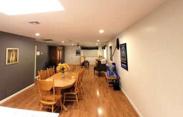 Large dining table surrounded by wooden chairs in a well-lit room