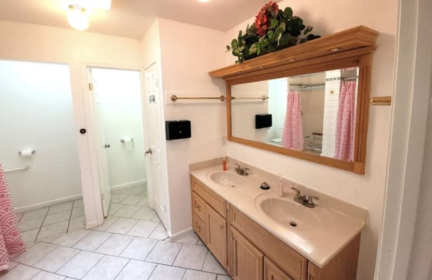 Bright and clean shared bathroom with double sinks and a mirror