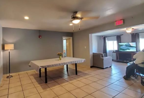 A well-lit common area with a table, chairs, and a couch.