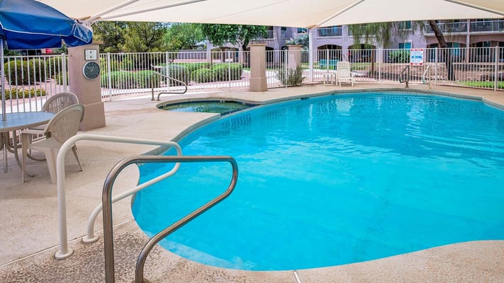 Swimming pool area with lounge chairs and shade