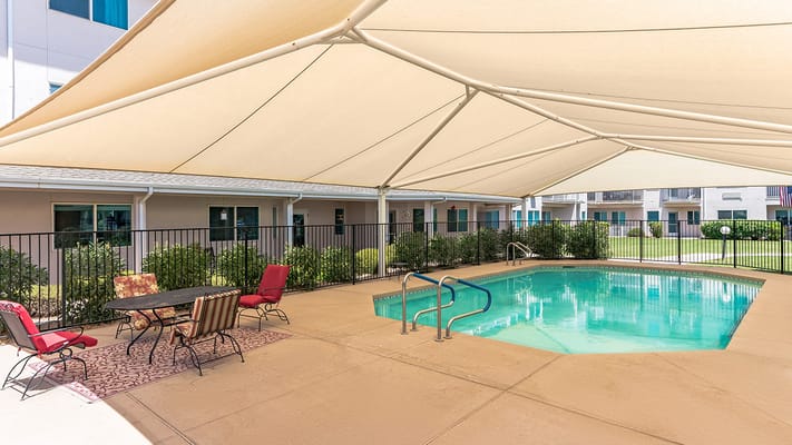 Outdoor pool area with seating and shade