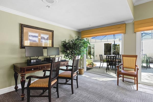 Common area with tables and chairs, opening to an outdoor space.