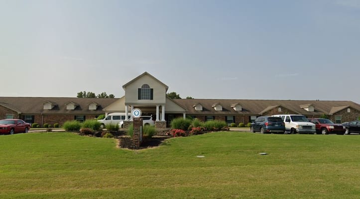 Exterior view of a senior care facility with vehicles
