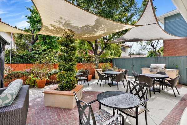 Outdoor patio area with shaded seating and plants