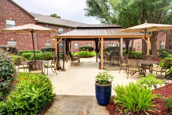 Covered patio area with seating and greenery