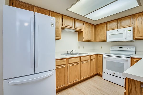 Bright kitchen with white appliances and wooden cabinets