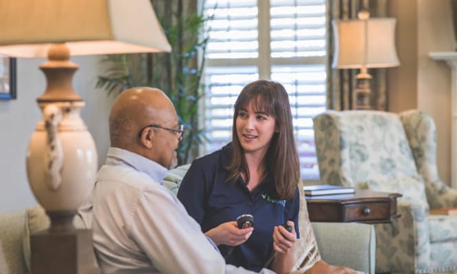 Staff member engaging with a resident in a cozy lounge area