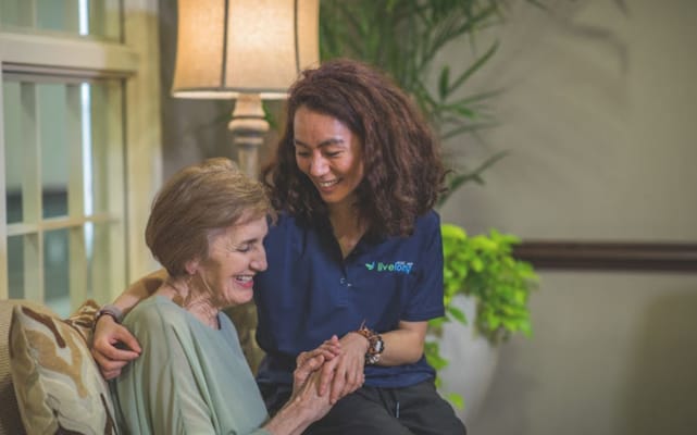 A caregiver bonding with a resident in a cozy lounge