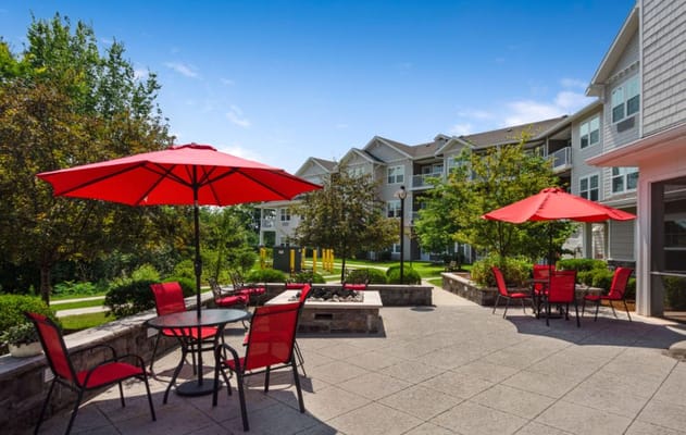Bright outdoor patio with red umbrellas and seating
