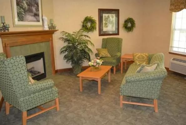 Comfortable green seating area with a fireplace and decor