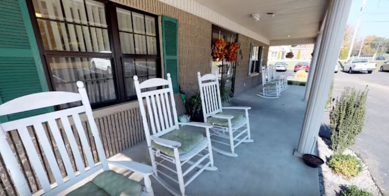 Row of white rocking chairs on the porch