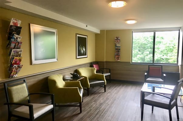 Bright common area with seating and magazine rack
