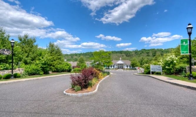 Driveway leading to a senior living facility with landscaped gardens