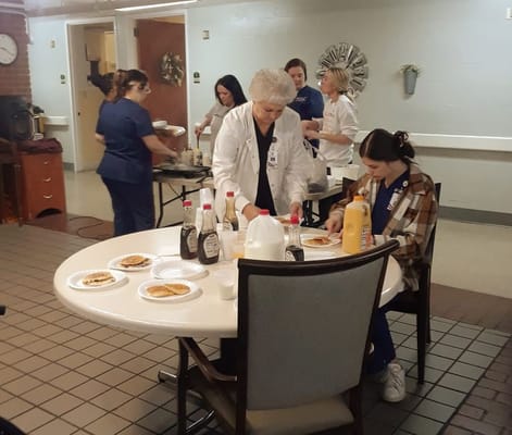 Staff preparing a meal with residents in a common area