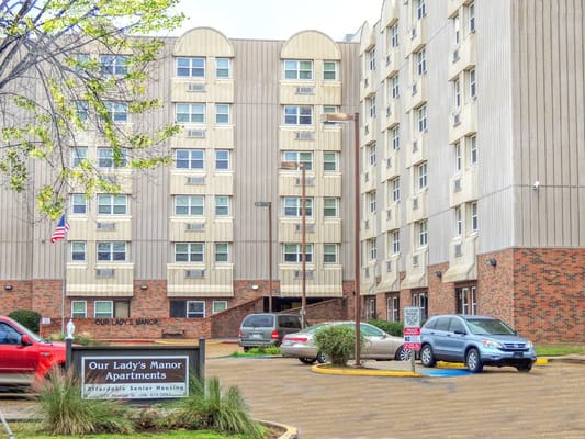 Exterior view of Our Lady's Manor apartments with signage