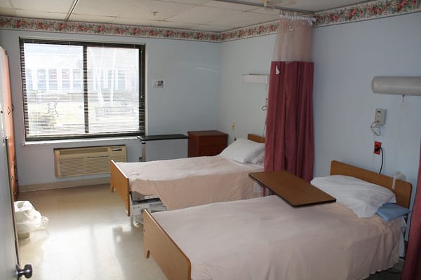 A shared resident room with two beds and a window