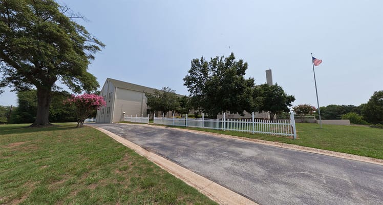Exterior view of PruittHealth - Decatur Nursing Home with trees and American flag.
