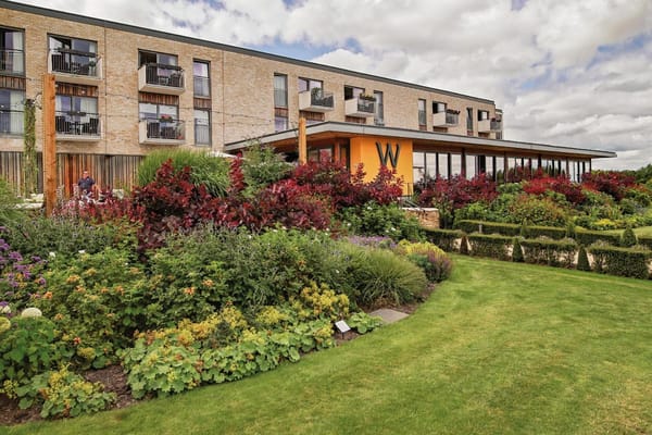 Exterior view of a senior living facility with colorful gardens