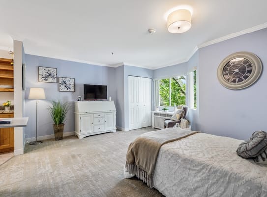 Spacious bedroom with a bed, TV, and seating area.