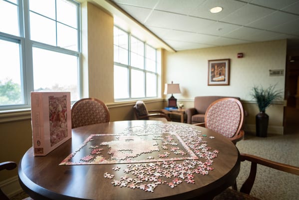 Table with a jigsaw puzzle and a book in a cozy sitting area