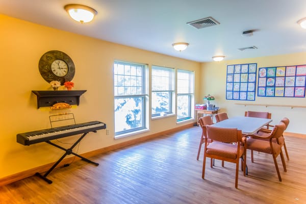 Bright common area with tables and musical keyboard