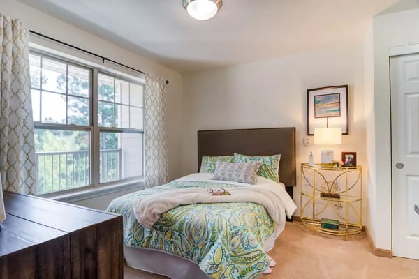 Bright and inviting bedroom with a bed, soft bedding, and natural light