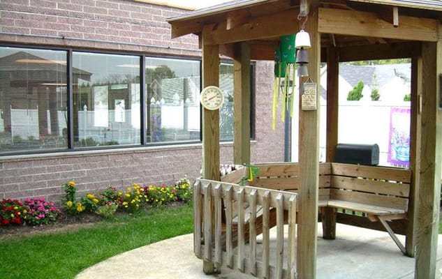Wooden gazebo with seating surrounded by flowers