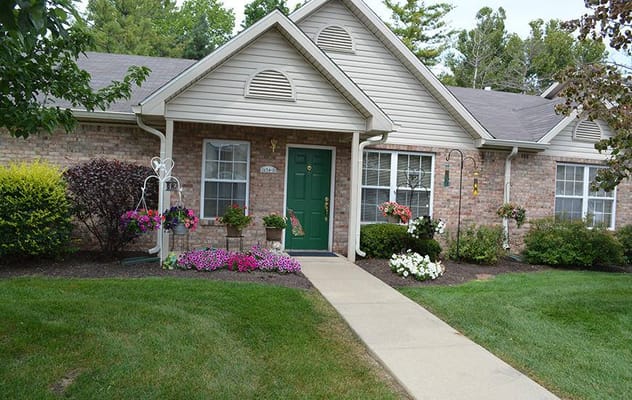 Front entrance of a senior living facility with landscaped flowers