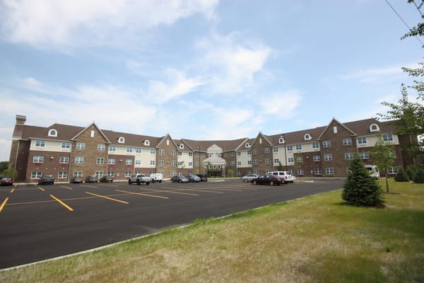 Exterior of St. Anthony of Lansing senior living facility with parking lot