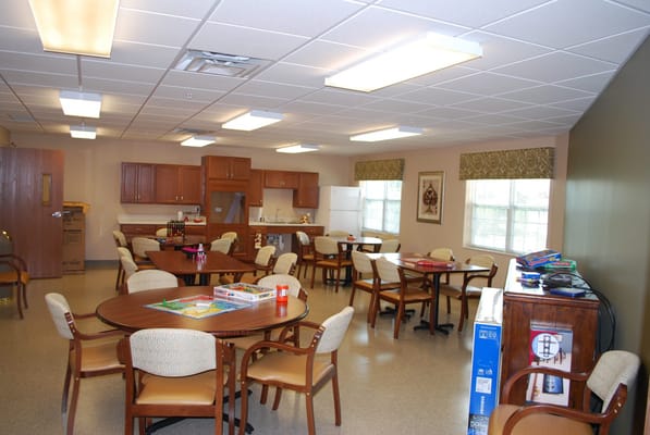 Bright common area with tables and chairs for residents.