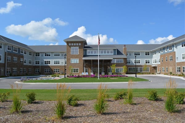 Front entrance of StoryPoint Schererville with landscaping and American flag