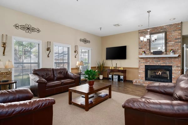 Spacious living room with leather couches and a fireplace