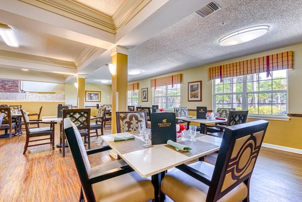 Bright dining room setup with tables and chairs at Sun City Senior Living