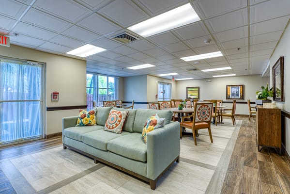 Bright and inviting common area with a couch and dining tables