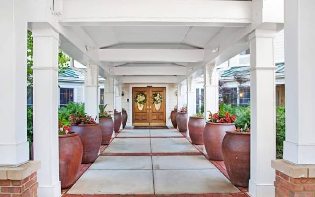 Exterior view of the main entrance with decorative pots and flowers.