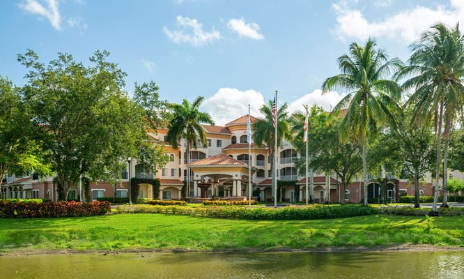 Front view of Terracina Grand with palm trees and lawn