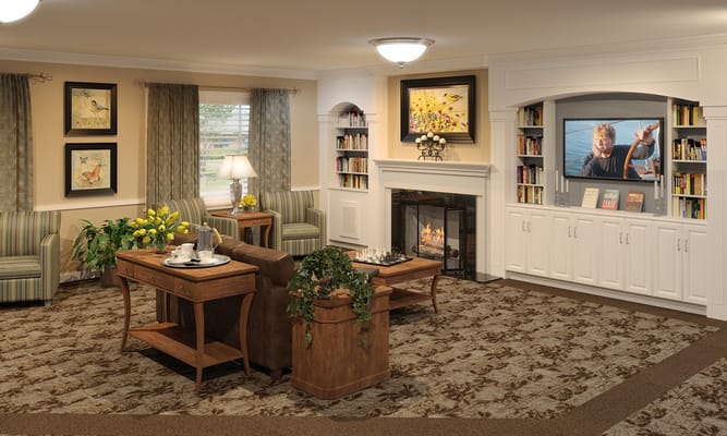 Cozy lounge area with seating, a fireplace, and bookshelves.