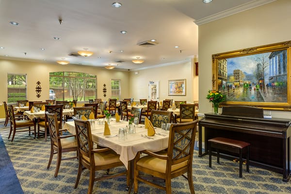 Spacious dining room with tables set for dining and a piano
