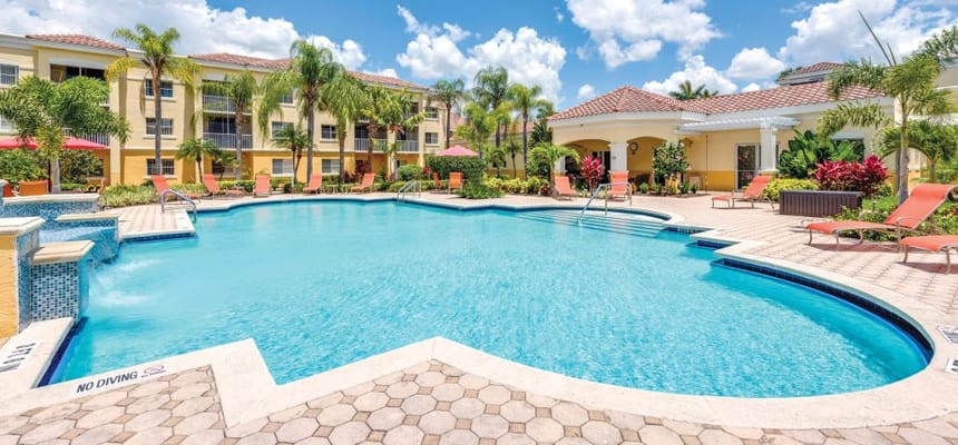 Outdoor swimming pool with lounge chairs and palm trees