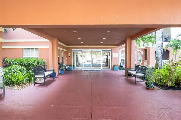Entrance area with benches and greenery at The Collier at Naples