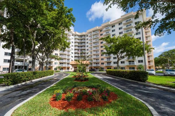 Exterior of The Court at Palm Aire with landscaped entrance