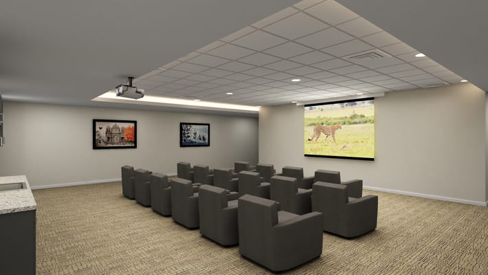 Cozy theater room with reclined seating and projector screen