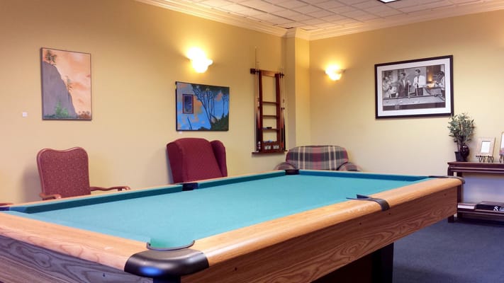 Billiards table in the recreation room with artwork on the walls