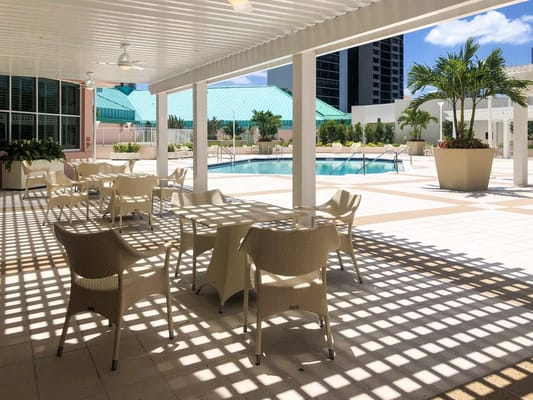Shaded seating area by the pool at The Glenview at Pelican Bay