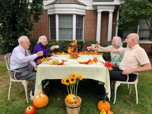 Residents enjoying tea outside in autumn.