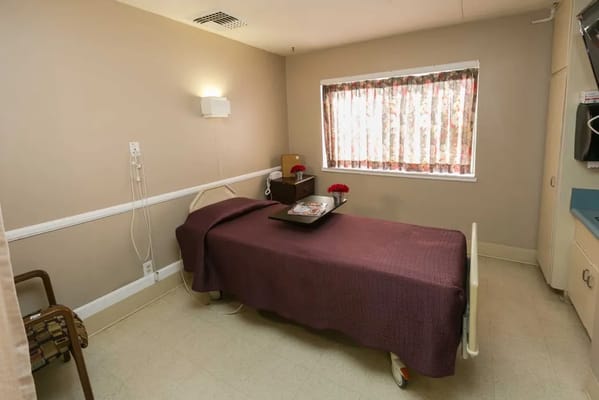 Cozy bedroom with a hospital bed and floral curtains