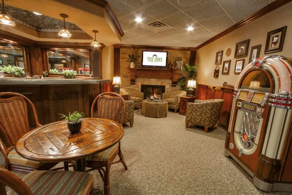 Cozy lounge with chairs, a table, and a jukebox